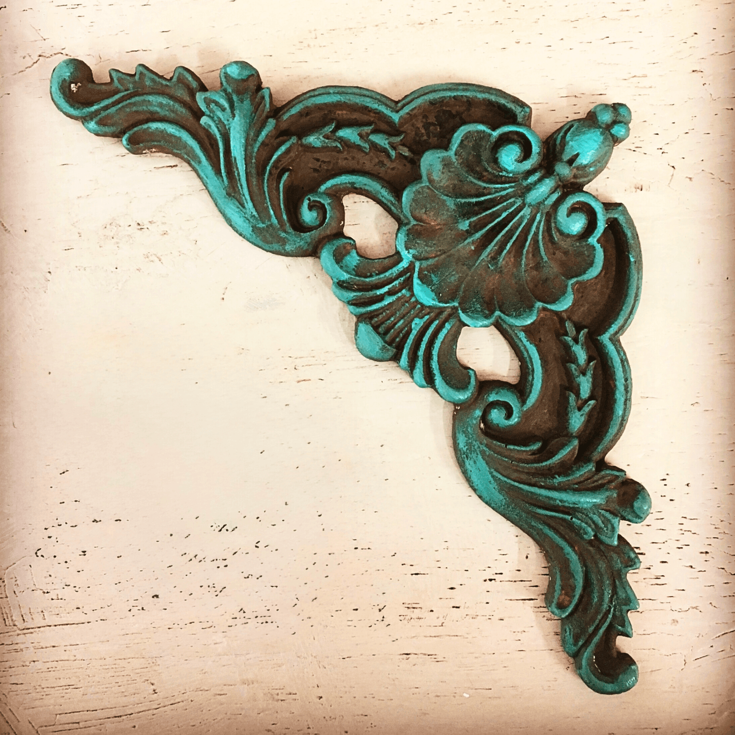 Ornate scrollwork corner applique painted and waxed on a light background