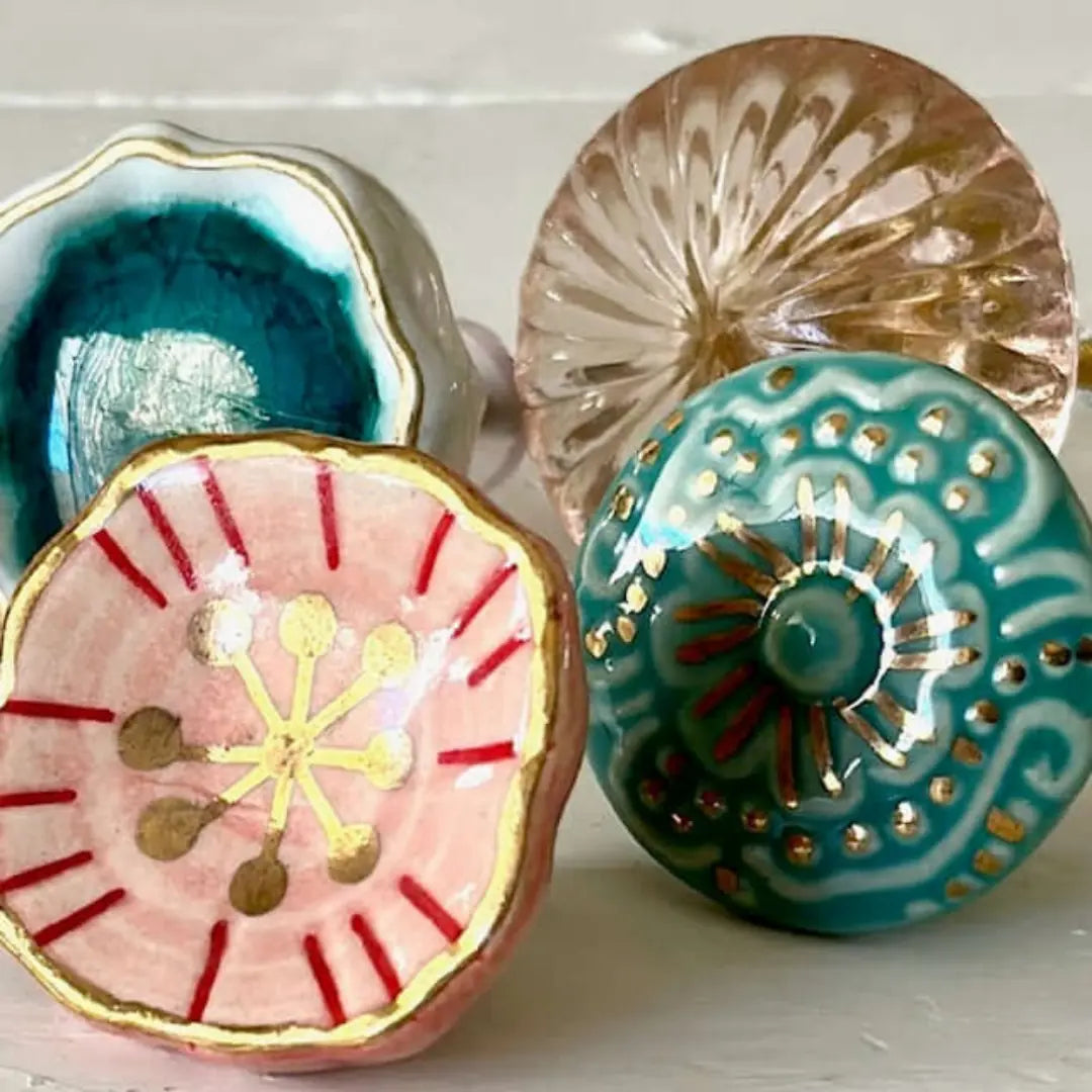 Group of decorative knobs including blush floral knob, turquoise ceramic, and glass designs.