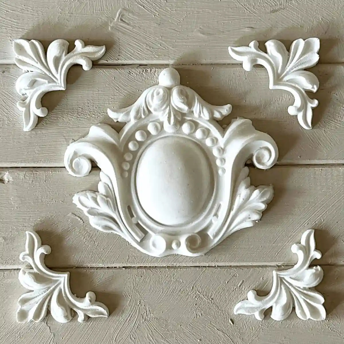 White ornate applique moulding set with central medallion and corner scrolls for furniture decor.