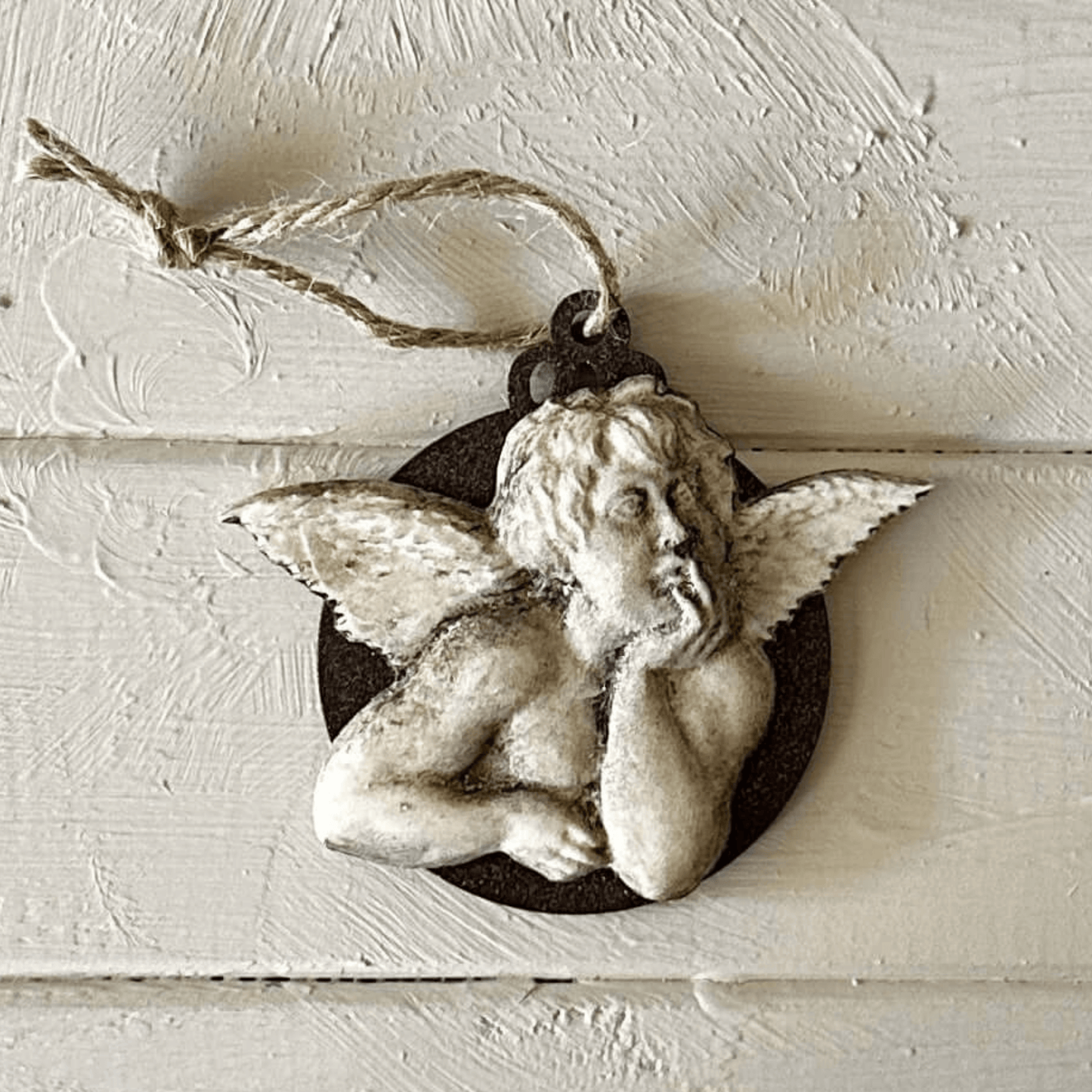 Angel 001 - Cherub Applique for Furniture & Craft Projects displayed on wooden surface with twine.