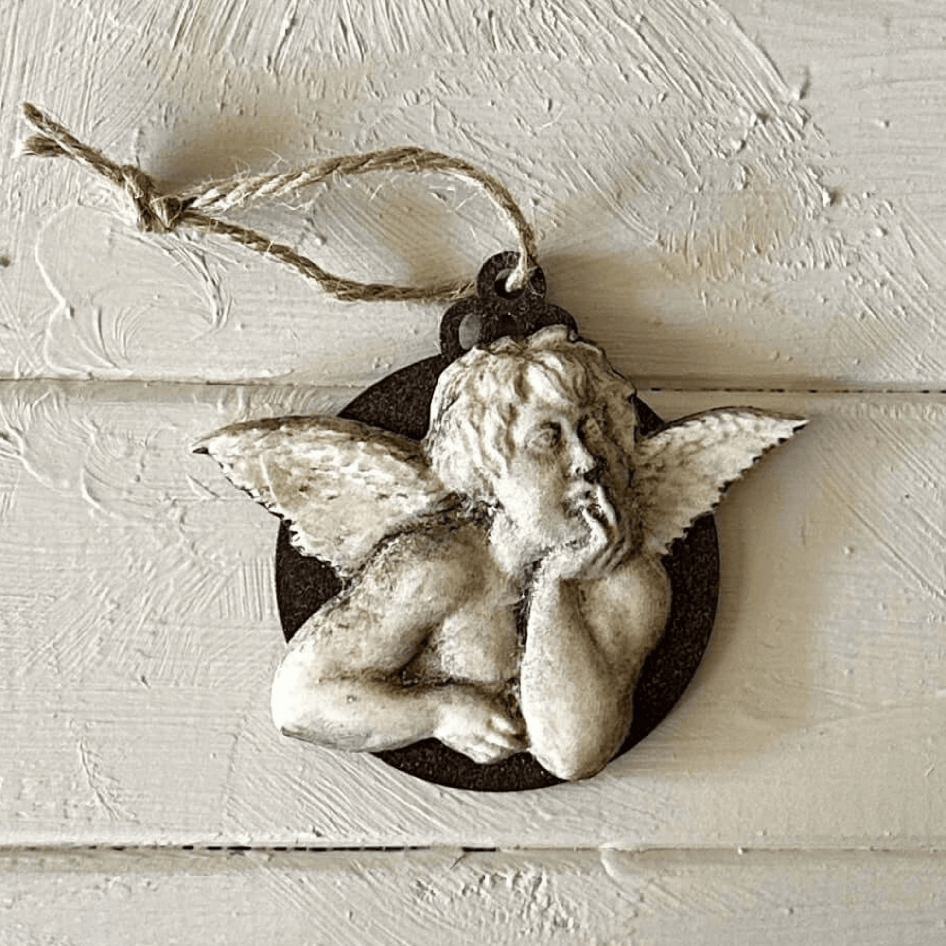 Angel 001 - Cherub Applique for Furniture & Craft Projects displayed on wooden surface with twine.