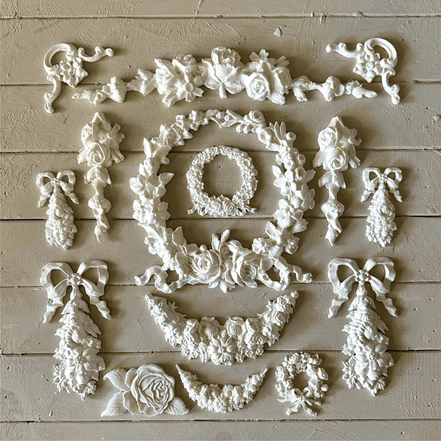 Swag 003 - Resin Applique for Furniture & Crafts arranged in a beautiful floral design on a light wooden surface.