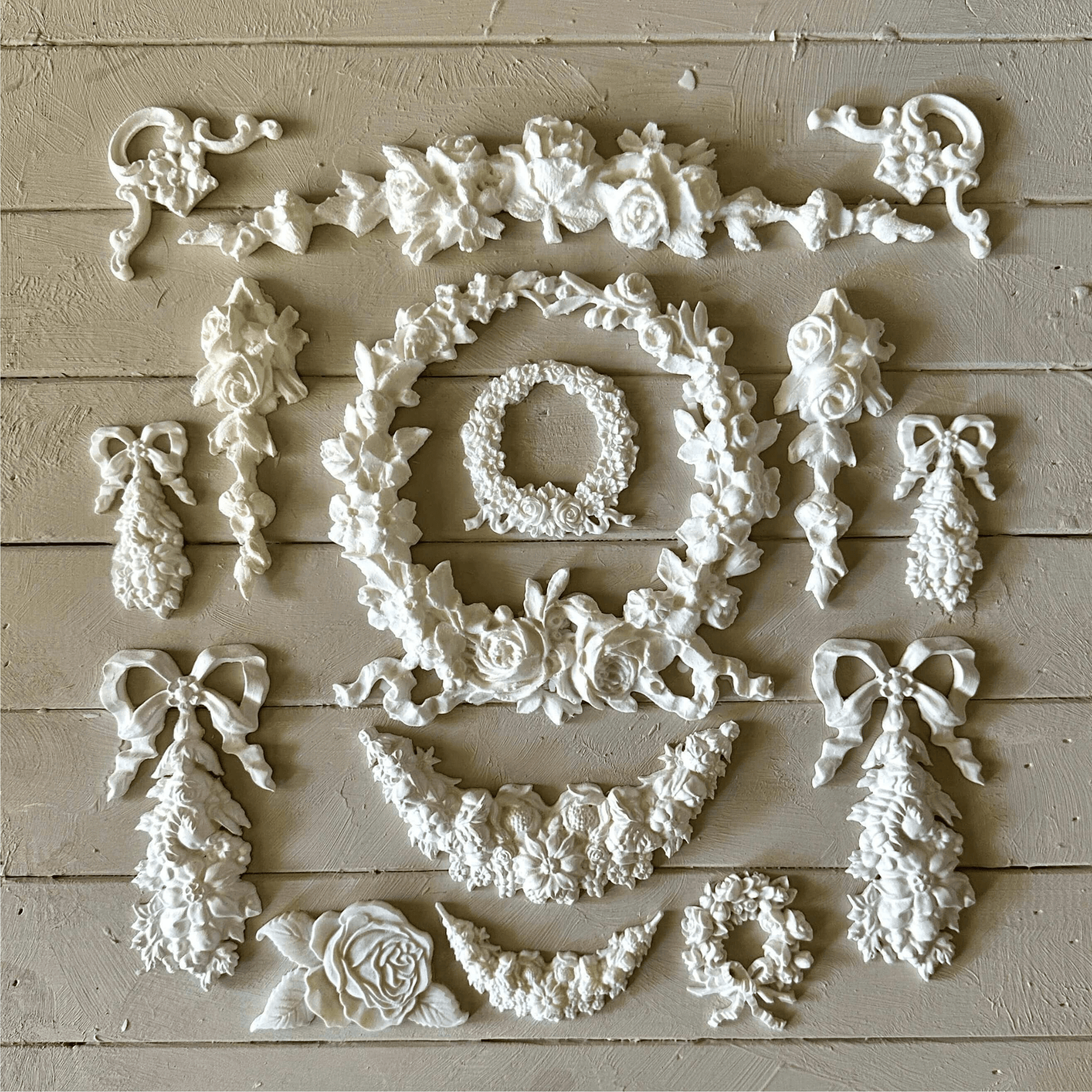 Swag 003 - Resin Applique for Furniture & Crafts arranged in a beautiful floral design on a light wooden surface.