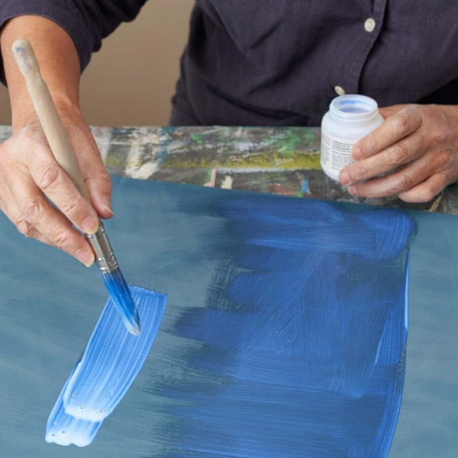 Annie Sloan Gold Size jar nearby as artist paints blue on canvas with a wide brush (100ml).