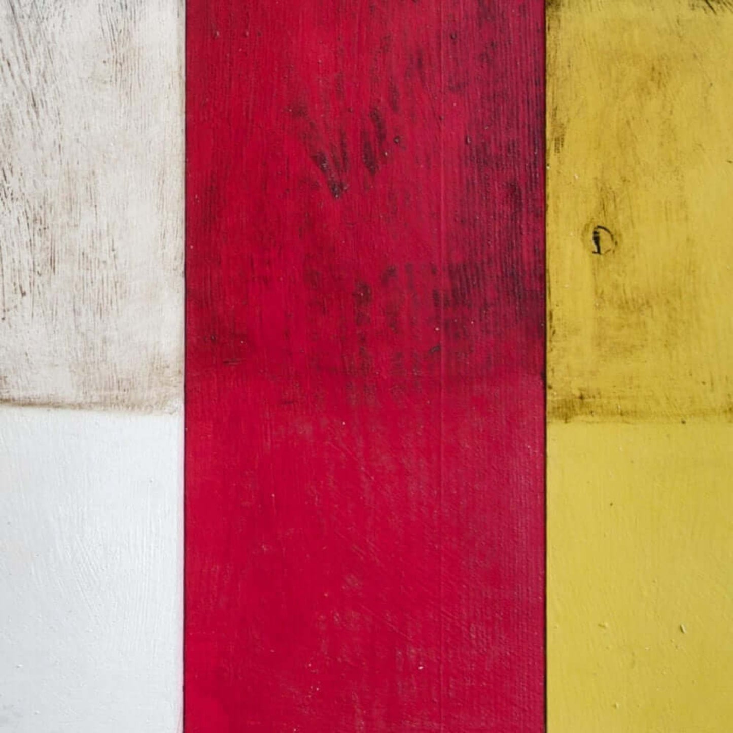 Annie Sloan Dark Chalk Paint in vibrant red, white, and yellow hues on wooden surface for furniture and décor.
