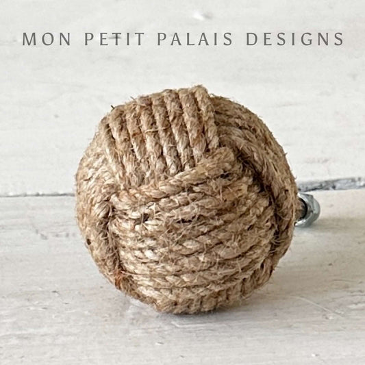 Nautical knot cabinet knob made of rope on a light wooden surface with 'Mon Petit Palais Designs' text.