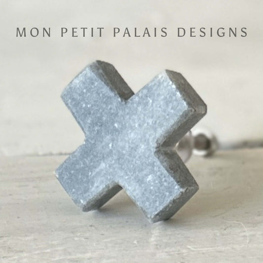 A grey marble cross-shaped knob for furniture.