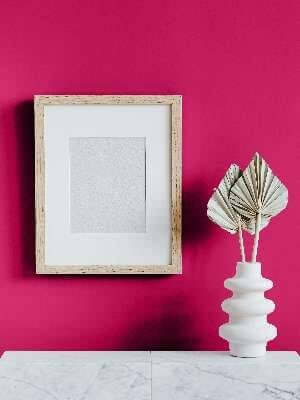 Capri Pink - Annie Sloan Wall Paint accents a room with a pink wall, featuring a framed art piece and a decorative vase.