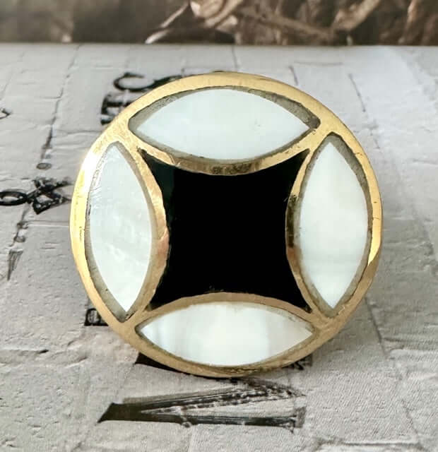 Flat lay of Alex brass and mother of pearl knob with bold diamond inlay - ideal for dresser drawers. cabinets or upcycled furniture.
