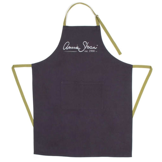 Black apron with gold straps and 'Annie Sloan' branding on a white background
