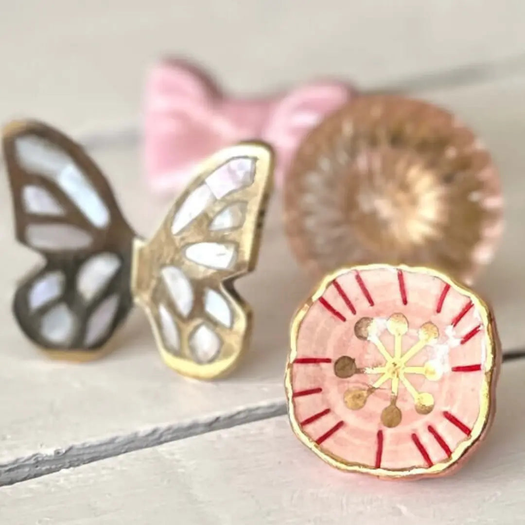 Styled ceramic knobs including blush & gold floral knob with butterfly design.