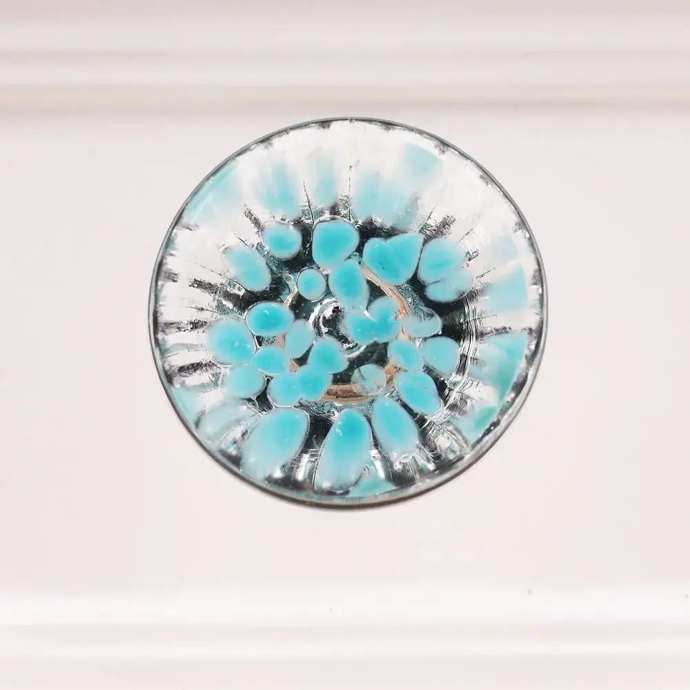 Round glass knob with blue fleck design on a white background