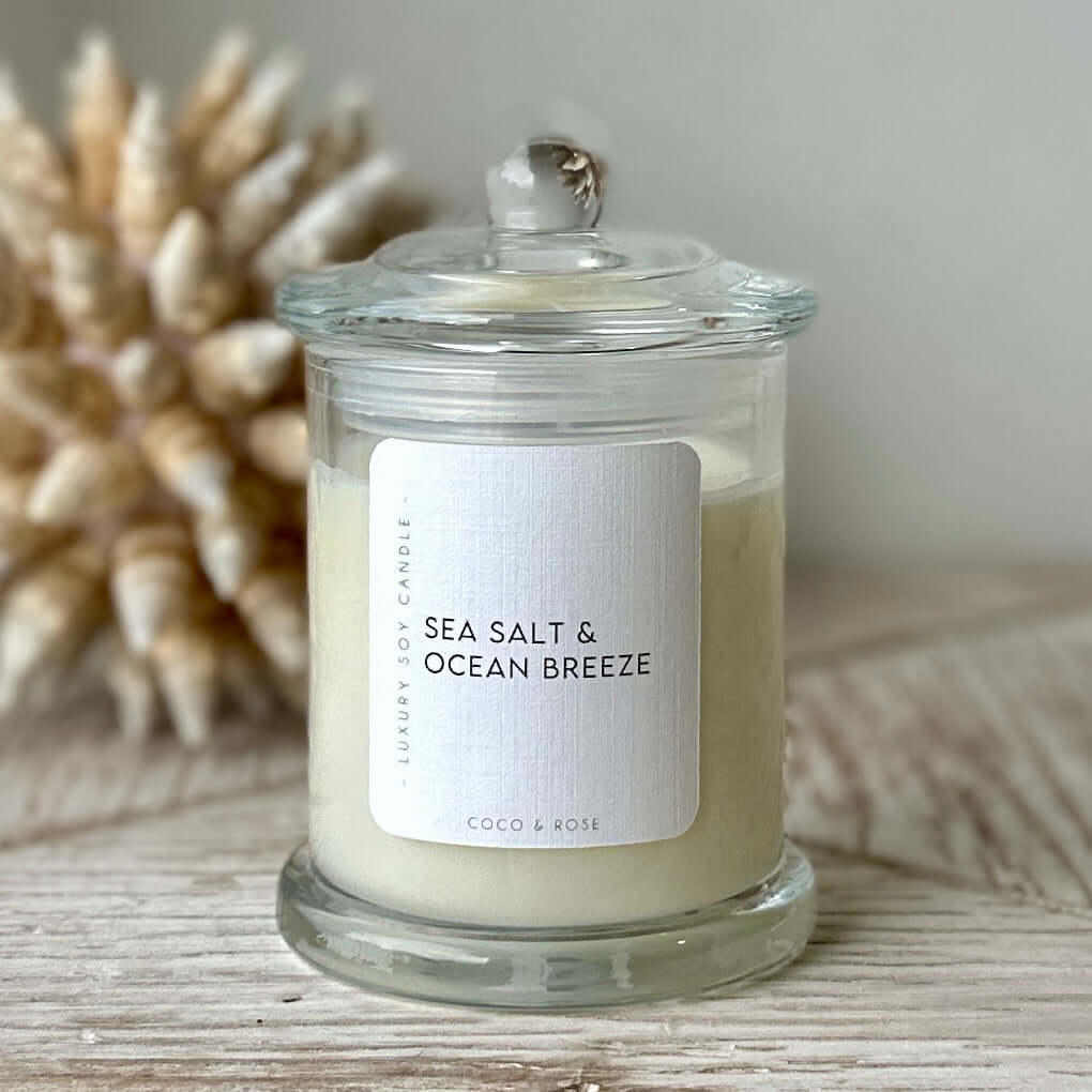 Signature Candle - Coastal Collection in clear glass jar with sea salt and ocean breeze scent.