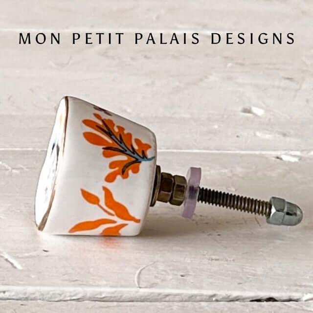 Orange & Blue Floral Hand-Painted Ceramic Knob showcasing vibrant orange and blue floral design on a stylish furniture knob.