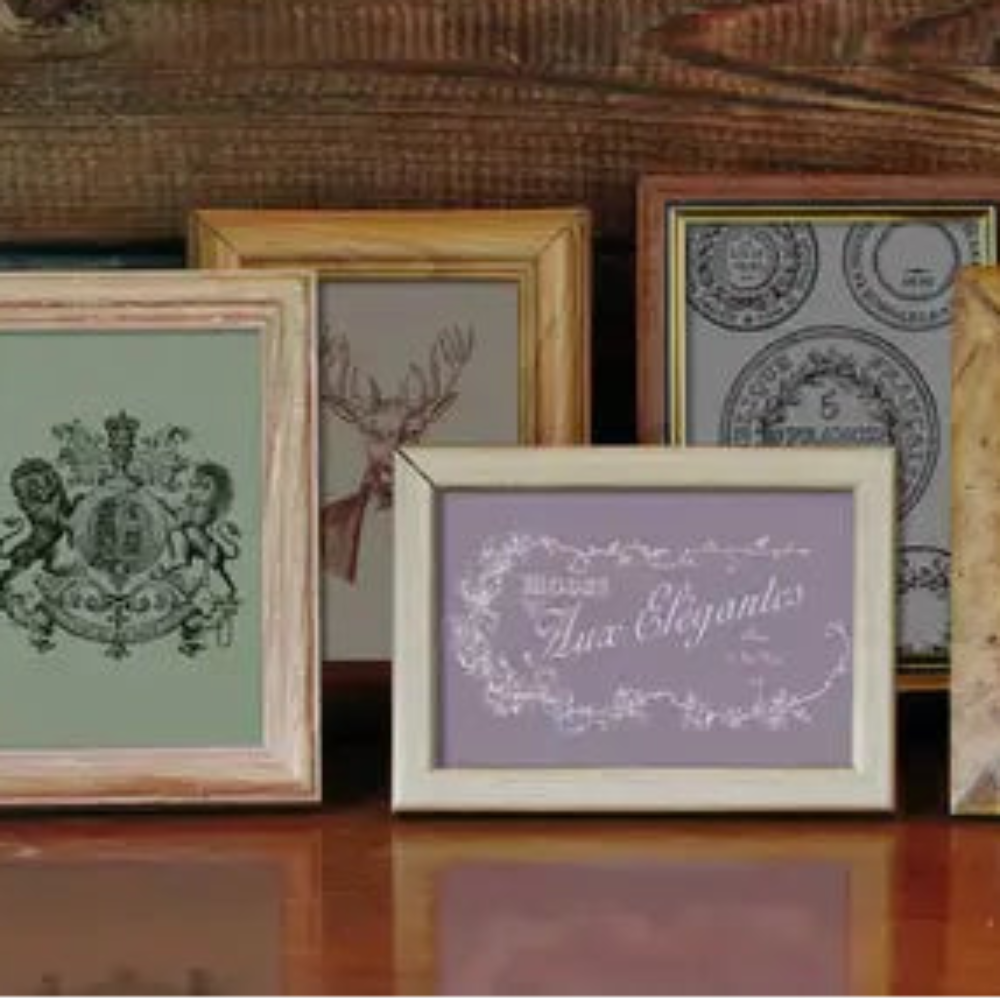 Collection of framed pictures on a wooden surface