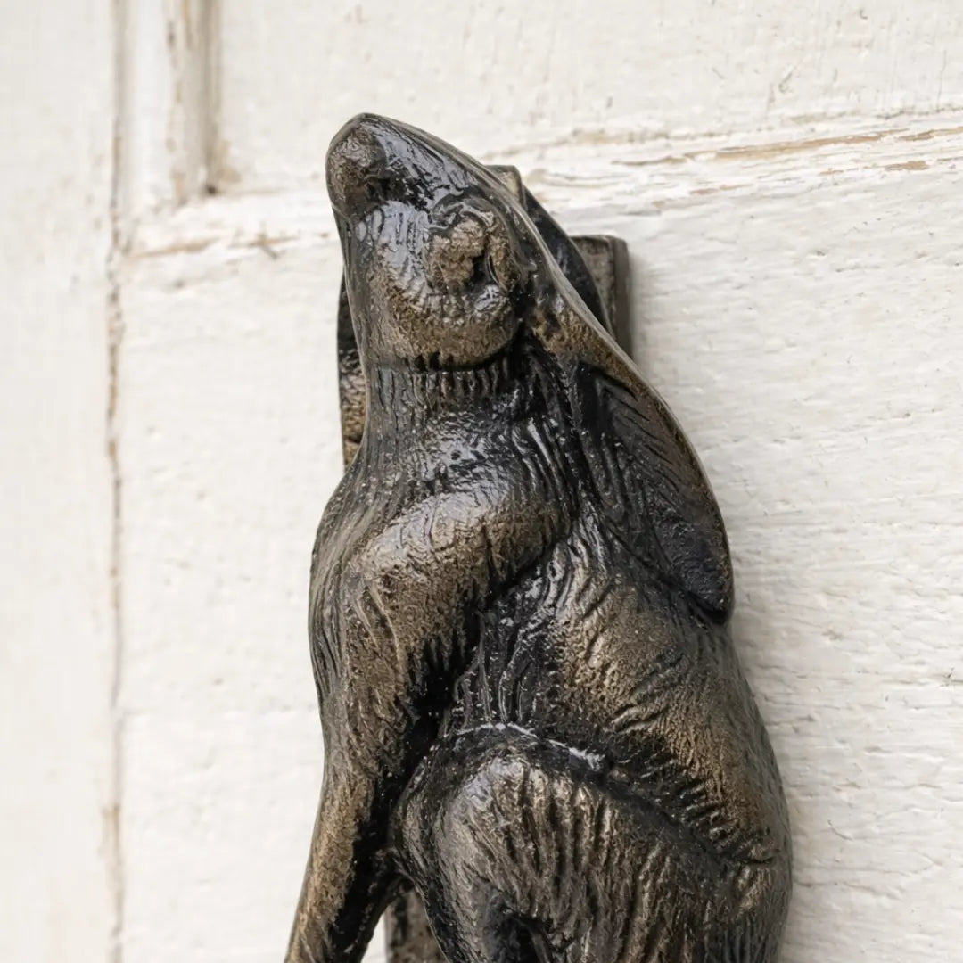 Close-up of the apin Classic French Rabbit Door Knocker mounted on a painted timber door, showcasing its aged bronze finish and timeless French country style.