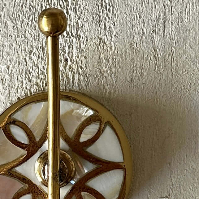 Mother of Pearl Wall Hook - Shell Inlay with brass and shell detailing on textured wall.