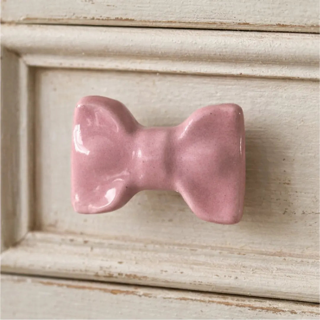 Pink Cute Ceramic Bow Cabinet Knob on a wooden dresser.