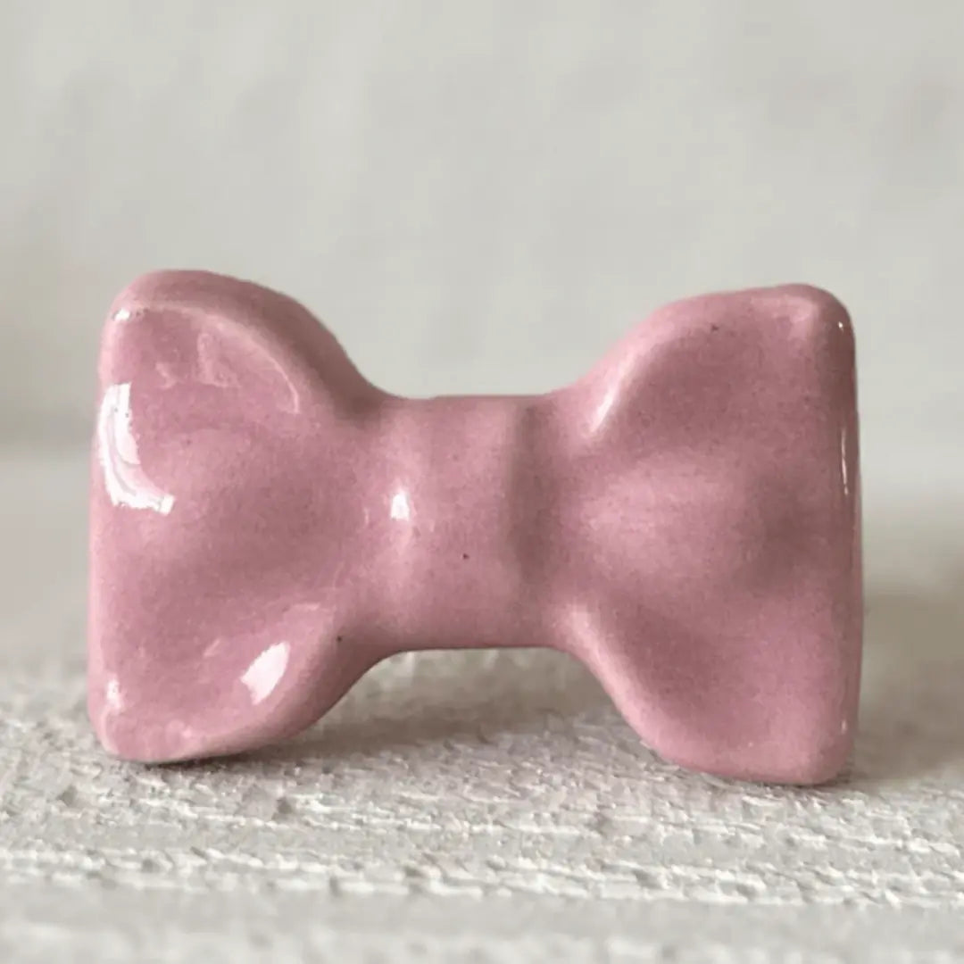 Pink Cute Ceramic Bow Cabinet Knob showcasing a glossy finish and whimsical bow design.