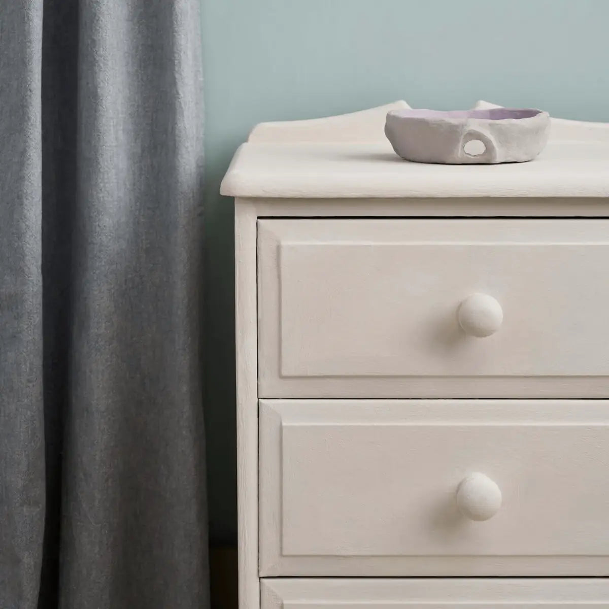 Close‑up of a bedside table showing the soft, creamy white colour and matte texture.