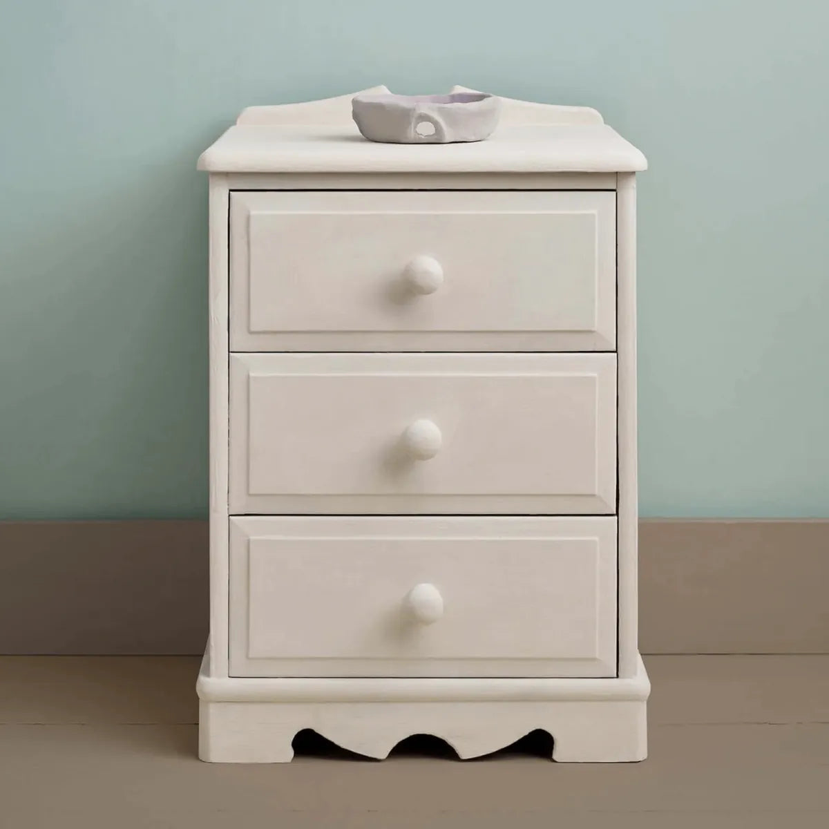 Small bedside table painted in a warm soft white with a smooth matte finish