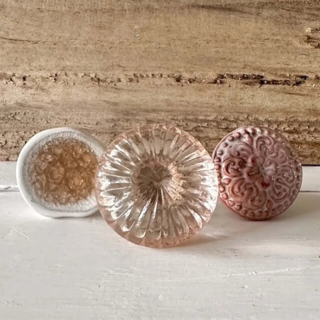 Rose Quartz Pink Glass Knob with set of three vintage-style furniture knobs, including a white ceramic knob with amber detail and a Henrietta Rose ceramic knob with a floral pattern. Ideal for furniture upcycling and home decor projects.