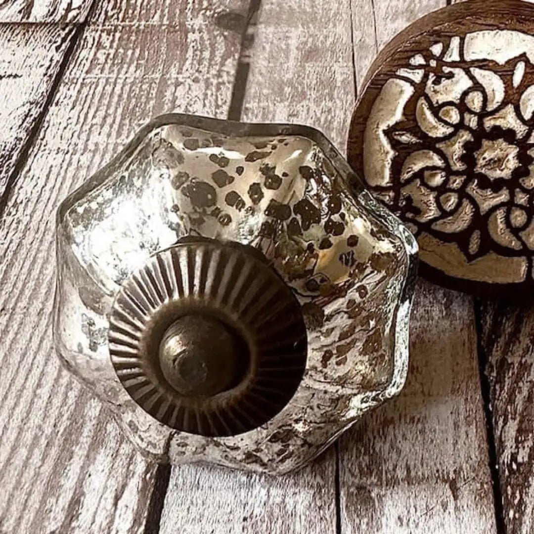 Styled flat lay of mercury glass knob with bronze centre and Zoe carved wood knob