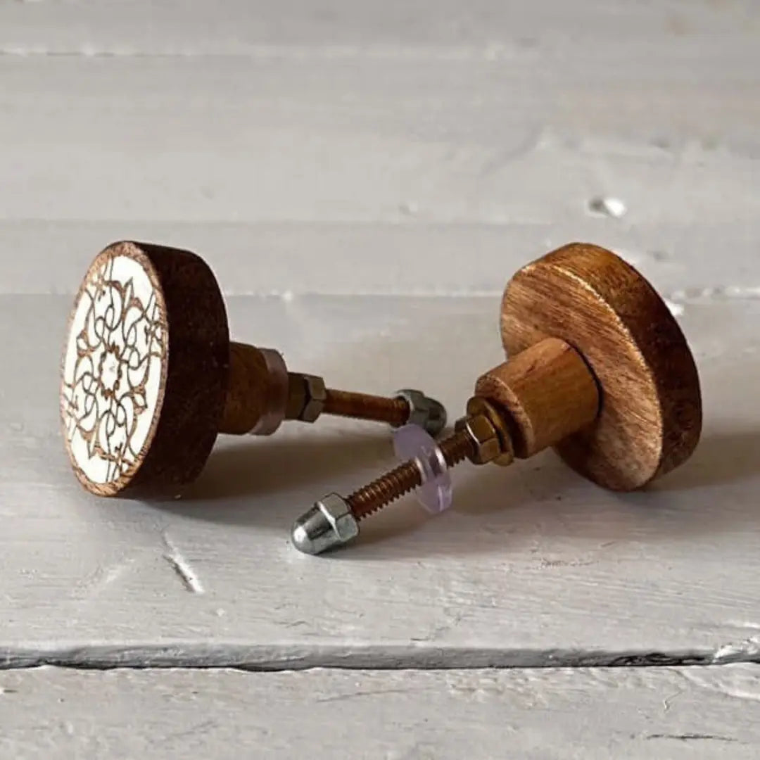 Pair of Zoe carved wood knobs with white mandala-style detail.