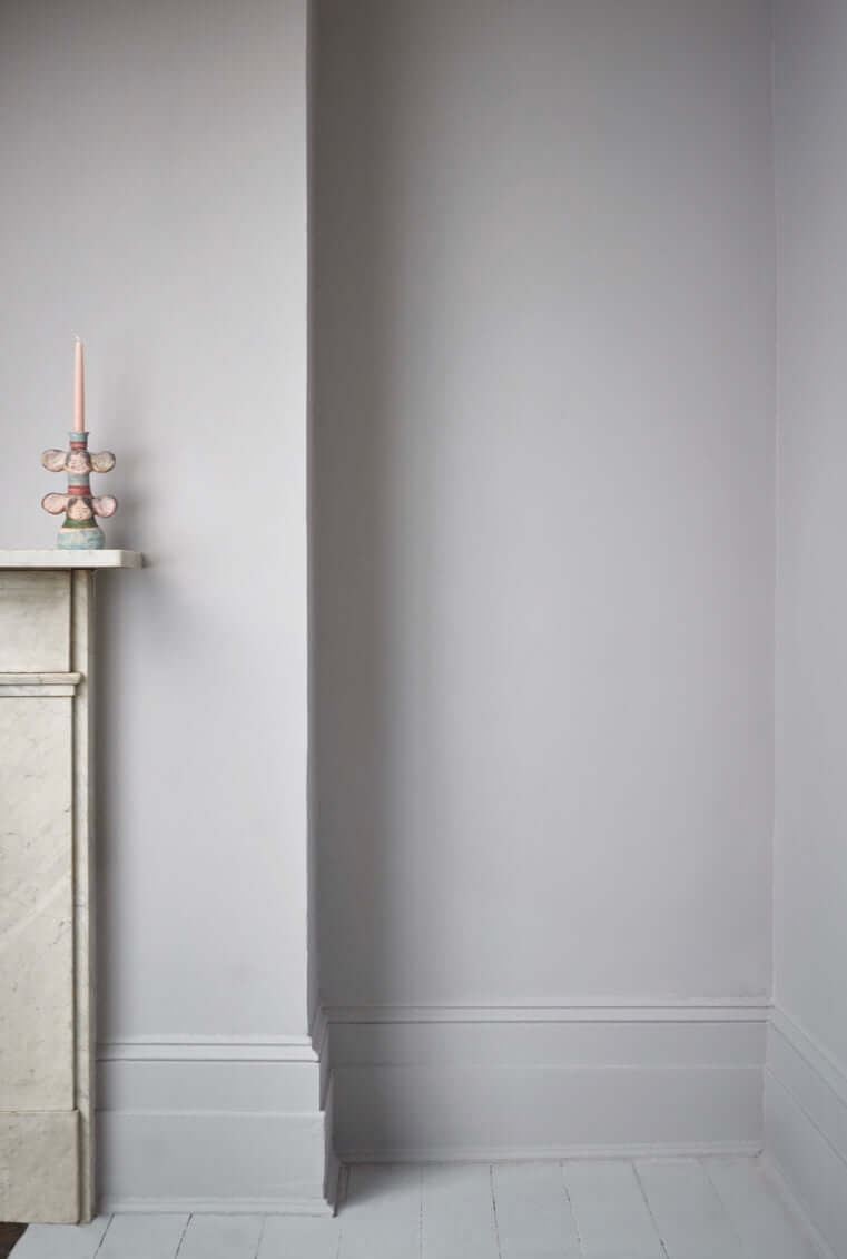 Chicago Grey - Annie Sloan Wall Paint wall corner with a candle holder and marble fireplace.